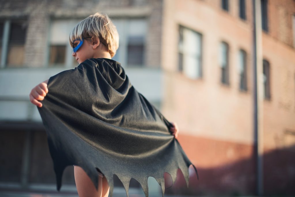 boy wearing black superhero cape and mask