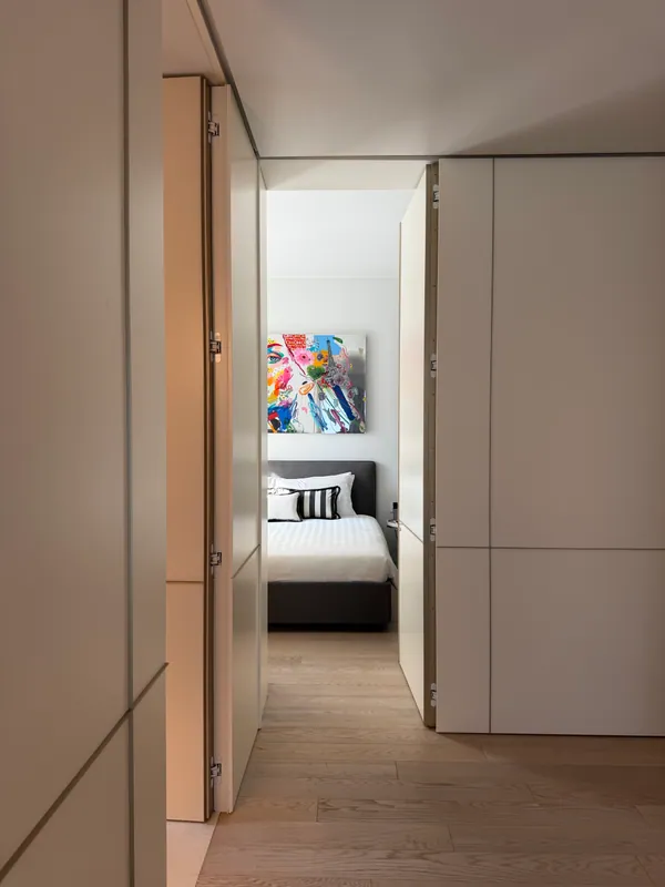 A suite doorway framing a contemporary bedroom and colorful artwork