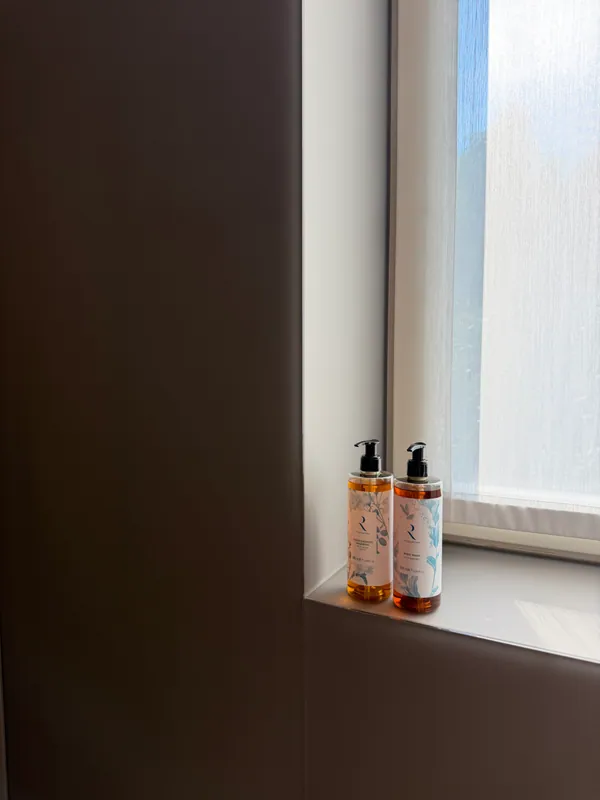 R Collection bath amenities beside a sunlit window